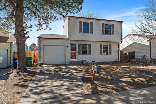 colonial inspired home featuring an attached garage, fence, and concrete driveway