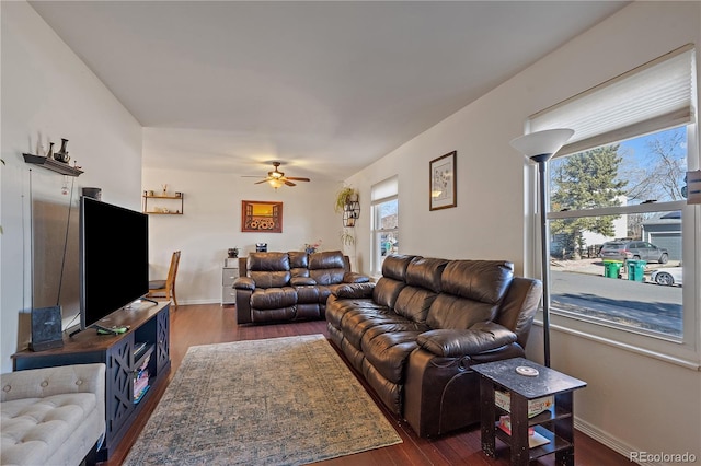 living room featuring ceiling fan, dark wood-style flooring, and baseboards