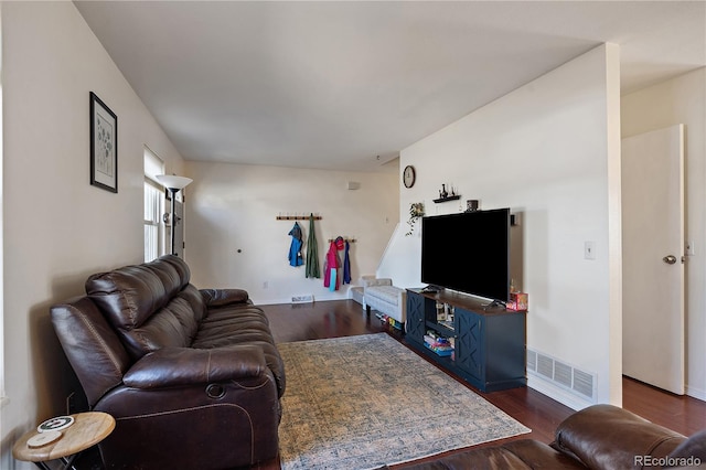 living room with dark wood-style flooring, visible vents, and baseboards