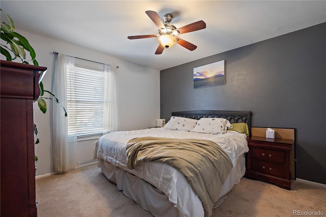 bedroom featuring a ceiling fan, light carpet, and baseboards