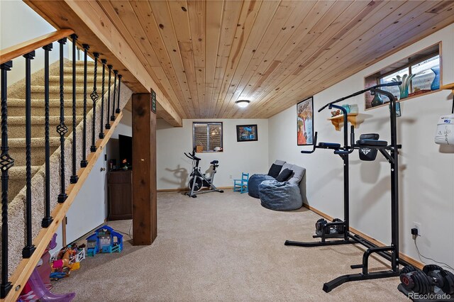 exercise area with wood ceiling, carpet flooring, and baseboards