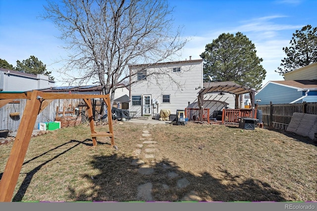 rear view of property featuring entry steps, a lawn, fence, and a pergola