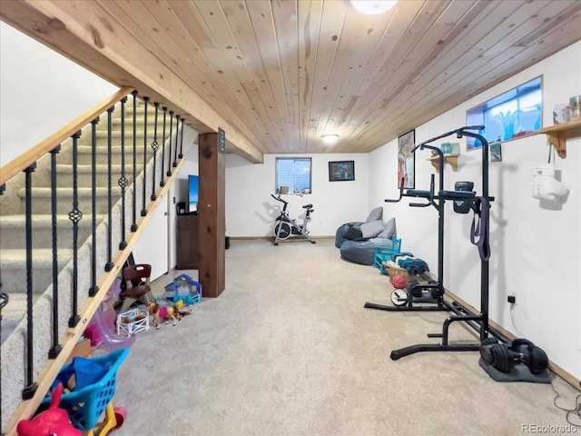 exercise area with baseboards, wooden ceiling, and carpet
