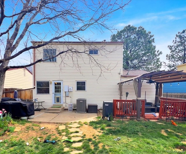 back of property featuring fence, a wooden deck, cooling unit, a patio, and entry steps