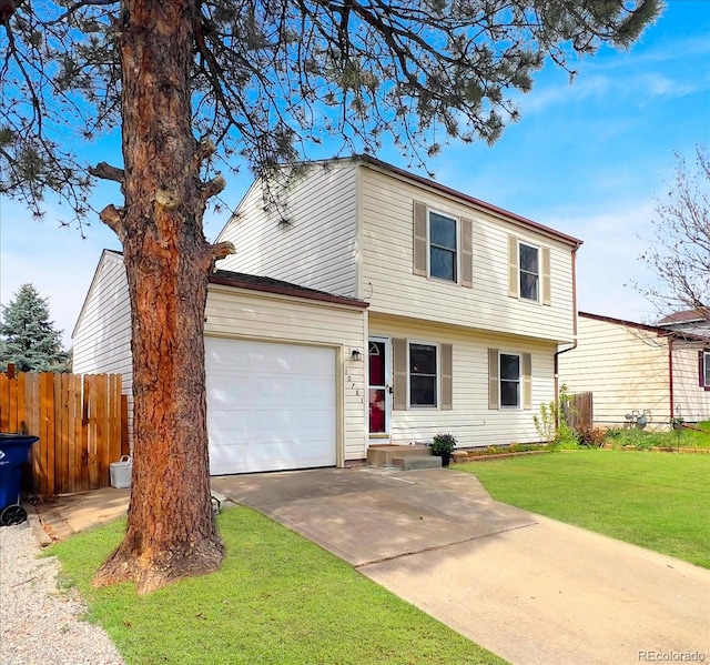 colonial-style house with fence, an attached garage, driveway, and a front lawn