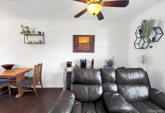 living area featuring baseboards, a ceiling fan, and wood finished floors