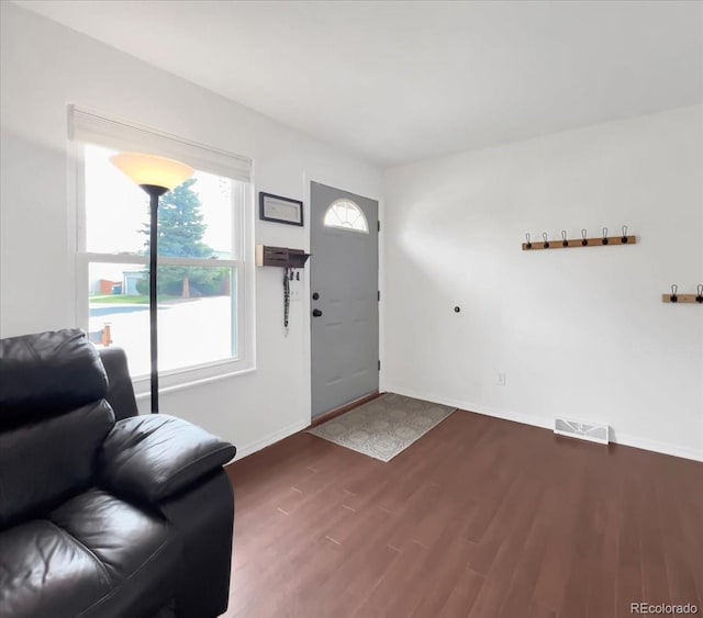 foyer entrance with baseboards, dark wood-style flooring, and visible vents