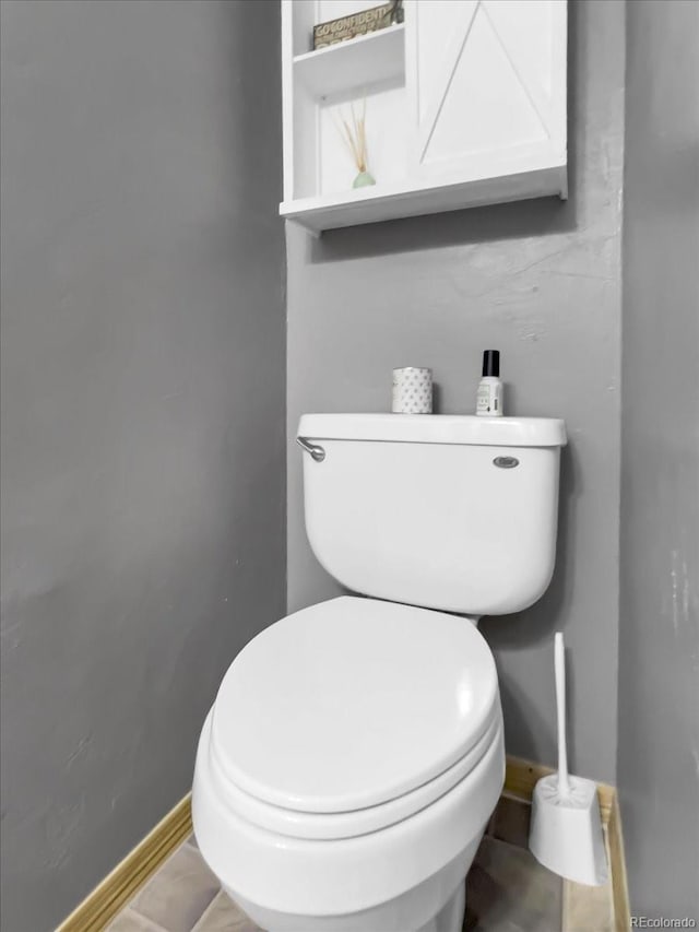 bathroom with baseboards and toilet