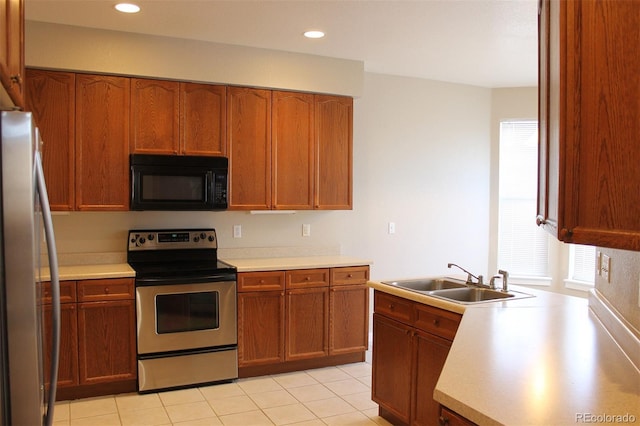 kitchen featuring light tile patterned flooring, appliances with stainless steel finishes, and sink