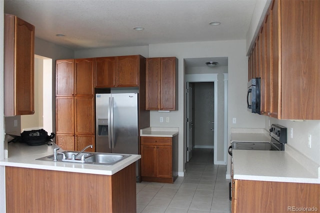 kitchen featuring sink, black appliances, kitchen peninsula, and light tile patterned flooring