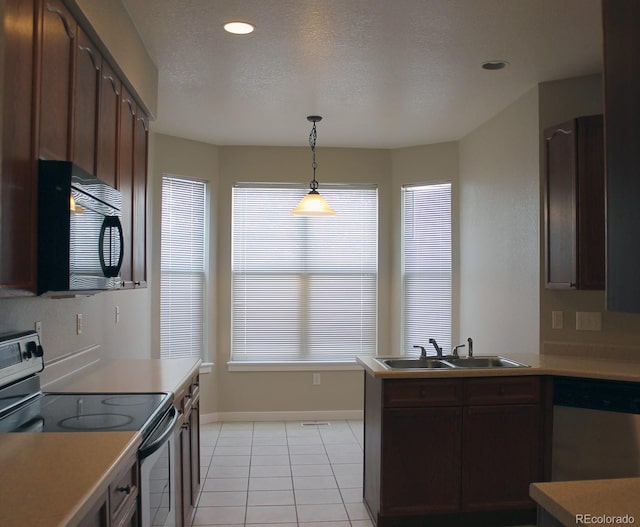 kitchen featuring sink, light tile patterned floors, dark brown cabinets, stainless steel appliances, and decorative light fixtures