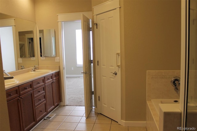 bathroom with vanity, tiled bath, and tile patterned flooring