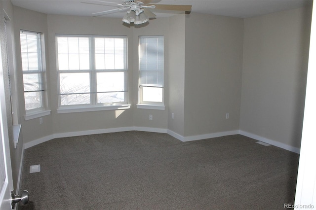 carpeted empty room with ceiling fan and plenty of natural light