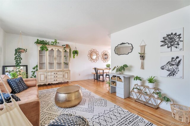 living area with light wood-type flooring and baseboards
