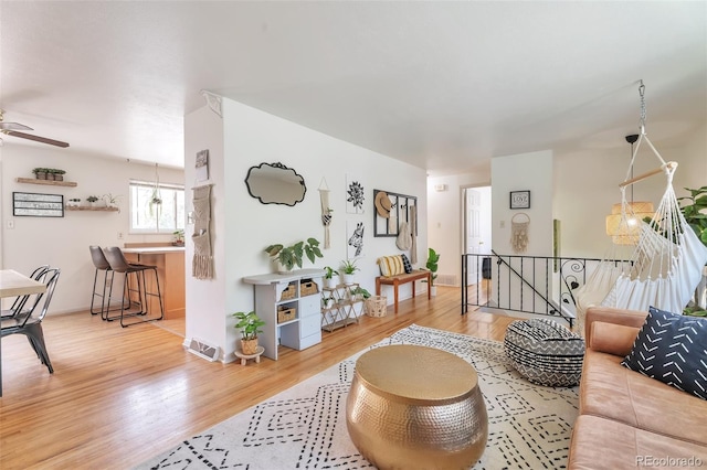 living area with wood finished floors and ceiling fan