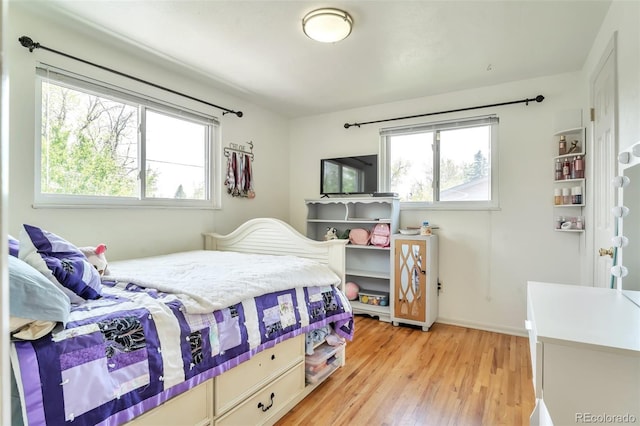 bedroom featuring multiple windows and light wood-type flooring