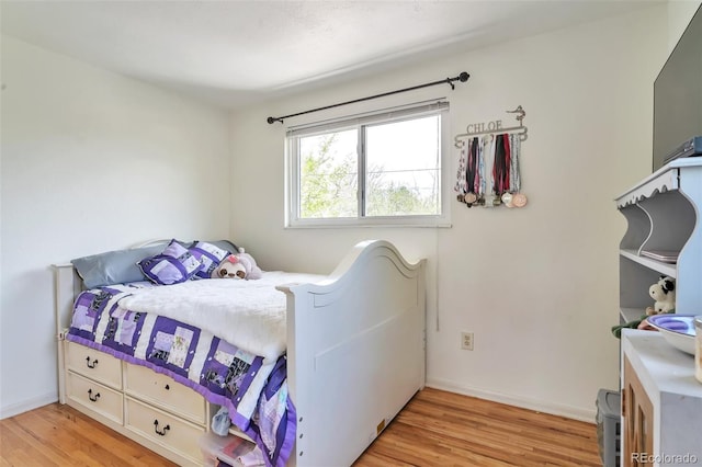 bedroom with light wood finished floors and baseboards