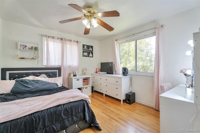 bedroom featuring light wood-type flooring, baseboards, and ceiling fan