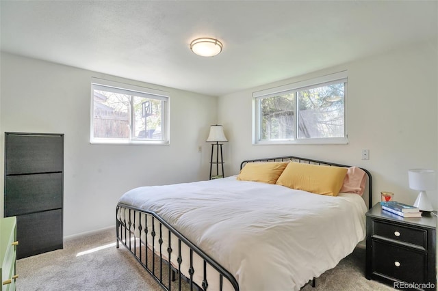 bedroom with multiple windows, carpet, and baseboards