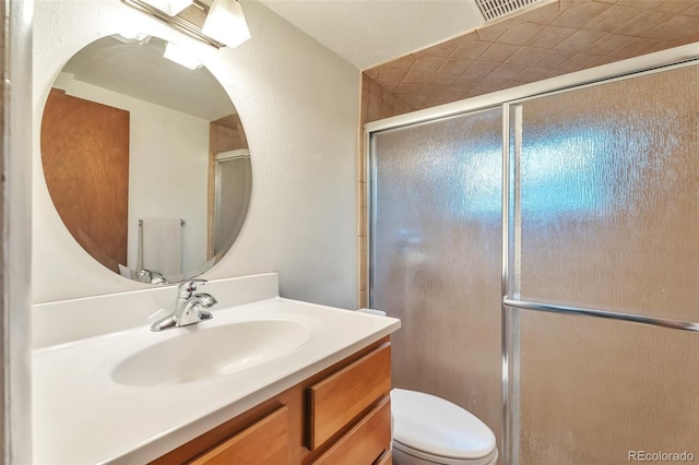 full bath featuring toilet, vanity, and an enclosed shower