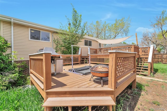 wooden deck with a fire pit and stairs