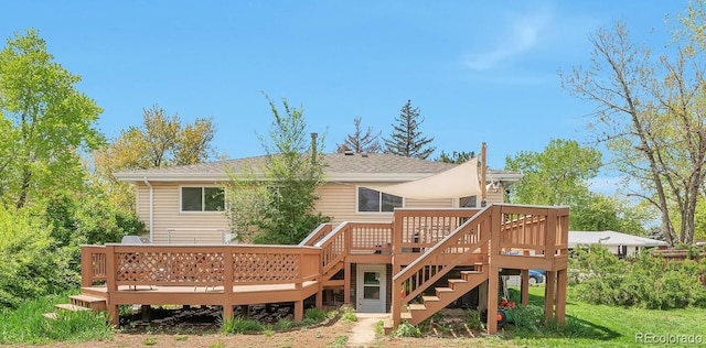 back of house with a deck, stairs, and roof with shingles
