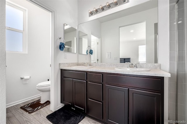 18199 E 96th Ave, Commerce City, CO 80022 - full bath featuring toilet, baseboards, double vanity, and wood finished floors