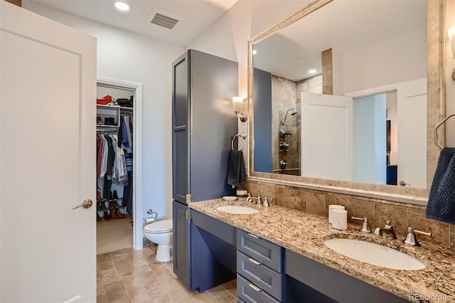 bathroom with vanity, toilet, backsplash, and walk in shower