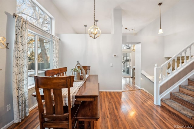 dining area with a chandelier, stairway, wood finished floors, and baseboards