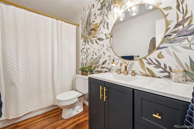 bathroom with toilet, curtained shower, wood finished floors, and vanity