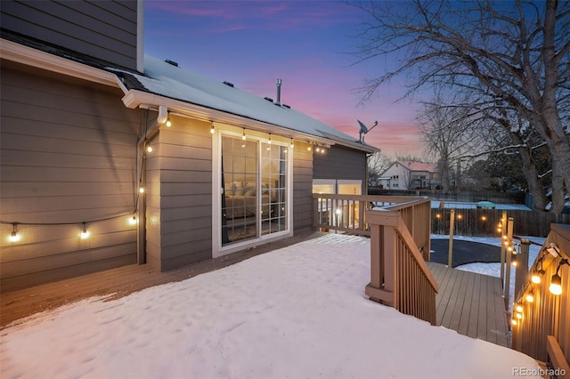 snow covered deck featuring fence