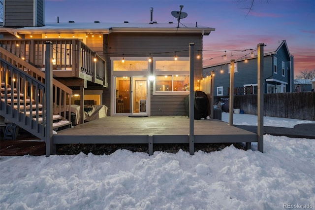 snow covered property featuring stairway, fence, and a deck