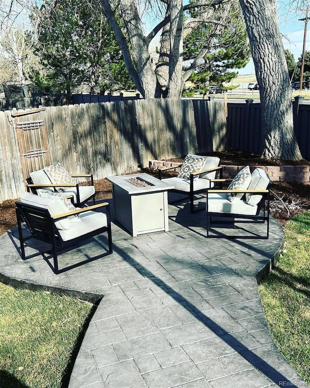 view of patio featuring an outdoor living space with a fire pit and a fenced backyard