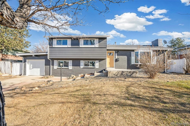 split level home with central AC unit, a garage, and a front lawn