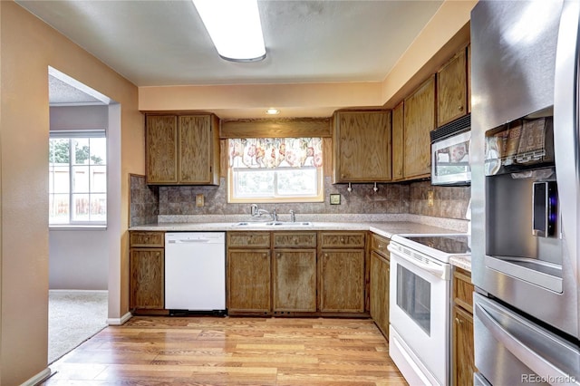 7300 Beech St, Arvada, CO 80005 - kitchen featuring appliances with stainless steel finishes, light countertops, a sink, and brown cabinetry