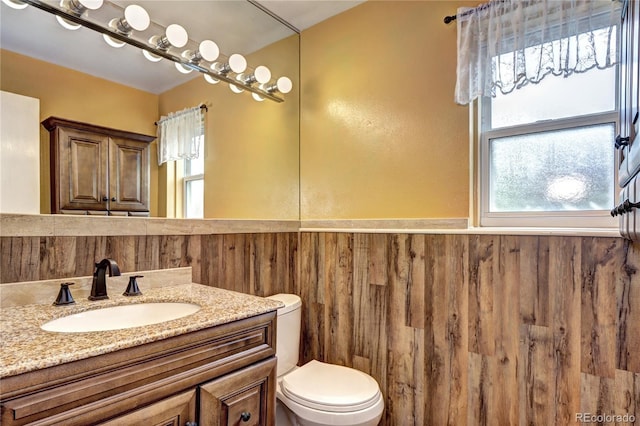 7300 Beech St, Arvada, CO 80005 - bathroom with wainscoting, vanity, toilet, and wooden walls