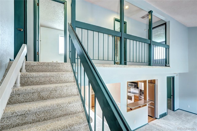 7300 Beech St, Arvada, CO 80005 - stairway with a textured ceiling, carpet floors, and baseboards