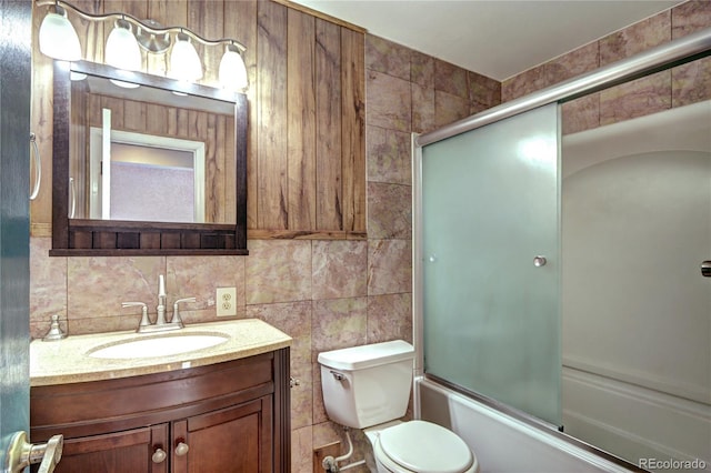 7300 Beech St, Arvada, CO 80005 - full bath with vanity, toilet, tile walls, shower / bath combination with glass door, and tasteful backsplash