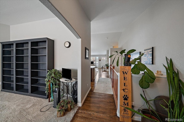 hall with built in shelves and dark wood-type flooring