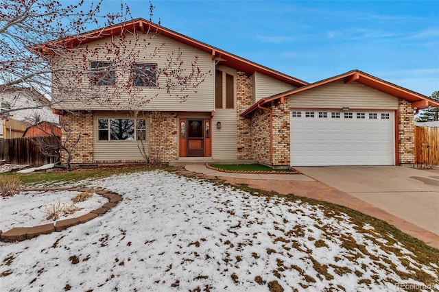 view of front of house featuring brick siding, an attached garage, concrete driveway, and fence
