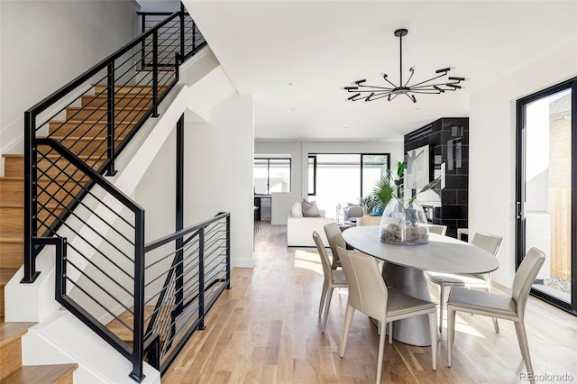 dining room with an inviting chandelier, a healthy amount of sunlight, and light hardwood / wood-style floors