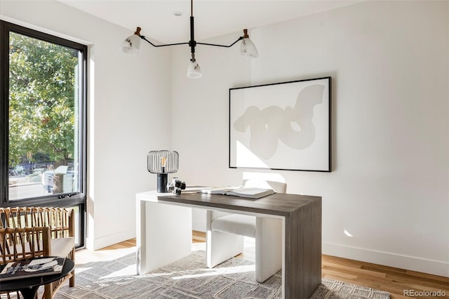 office space featuring an inviting chandelier and light wood-type flooring