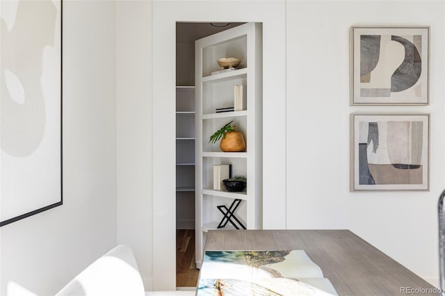 dining area featuring wood-type flooring and built in shelves