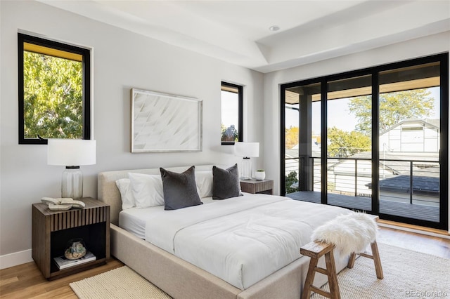 bedroom with access to outside and wood-type flooring