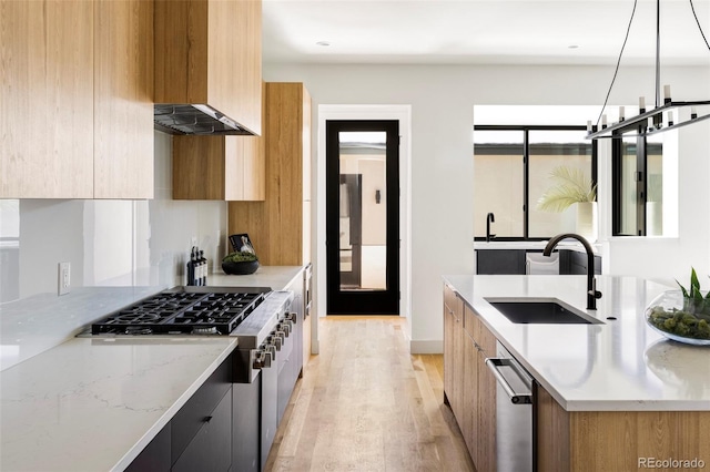 kitchen with dishwasher, sink, decorative light fixtures, light hardwood / wood-style floors, and light stone counters