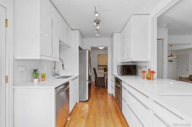 3209 E Yale Way, Denver, CO 80210 - kitchen featuring appliances with stainless steel finishes, white cabinets, backsplash, and light countertops
