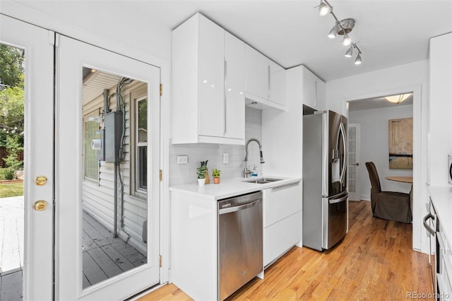 3209 E Yale Way, Denver, CO 80210 - kitchen with appliances with stainless steel finishes, white cabinets, light countertops, and backsplash