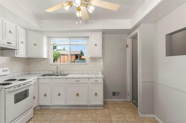 11917 Lavinia Way, Northglenn, CO 80233 - kitchen with electric range, a ceiling fan, white cabinetry, tile counters, and under cabinet range hood