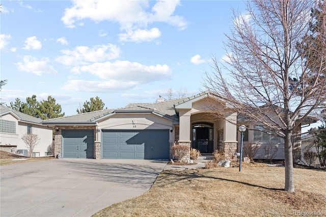 ranch-style home with concrete driveway, stone siding, a tile roof, an attached garage, and stucco siding