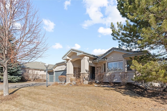 view of front of house featuring stone siding, driveway, an attached garage, and stucco siding